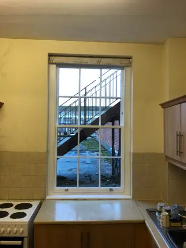 Traditional Sliding Sash Window - 
Traditional lead weight and putty glazed heritage units.
Made to specifications to match the listing requirements. 
Finished in exterior top coat.
Satin Chrome Pulls and Fastener. image