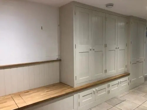 Oak Boot Room
Manufactured from European Oak
Brass hinges
Finished in Colour match to F&B Clunch.
Solid Oak Worktop with lifting lids for storage, finished in Clear Lacquer
Bead & Butt boarding to the back wall with an Oak Capping. image