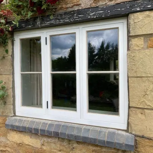 Stone Cottage - Traditional Casement Sash. Horizontal Glazing Bars with Ovlo mould. Manufactured from Accoya. Finished in White Top Coat. 14mm Heritage Planitherm Glazed Units. Traditionally puttied.  image